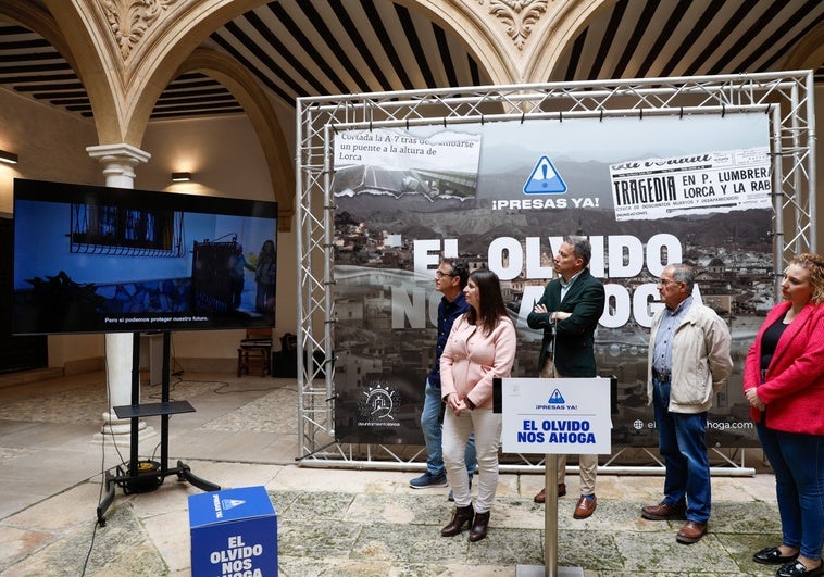 El alcalde y representantes de la plataforma de afectados por las inundaciones observan el spot publicitario de la campaña 'El olvido nos ahoga'.