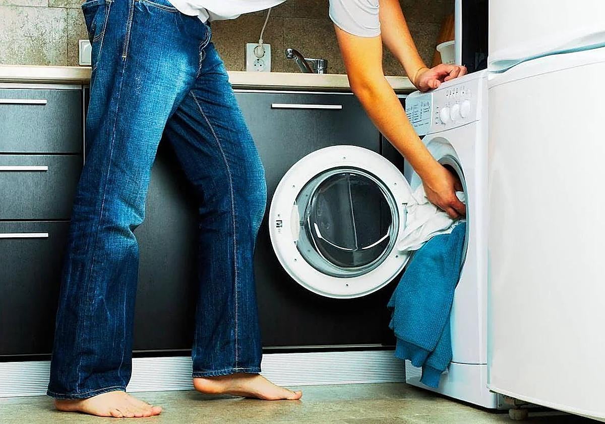 Un hombre poniendo la lavadora.