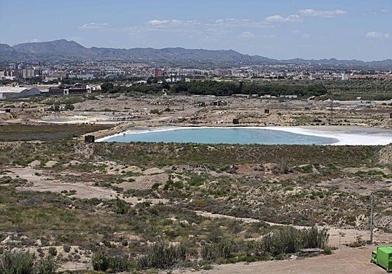 En primer término, una de las balsas de residuos peligrosos de Zinsa llena de agua; detrás, escombros de la demolida factoría Española del Zinc.