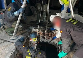 Un agente de la Guardia Civil se introduce en el depósito de aceite donde se encontraron los restos humanos.