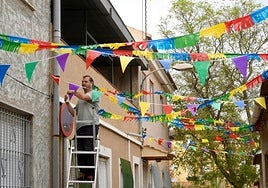 Un vecino decorando la calle San Luis de Churra, ubicada en el barrio de San Isidro.