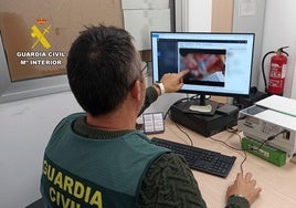 Un agente analizando una de las grabaciones obtenidas.