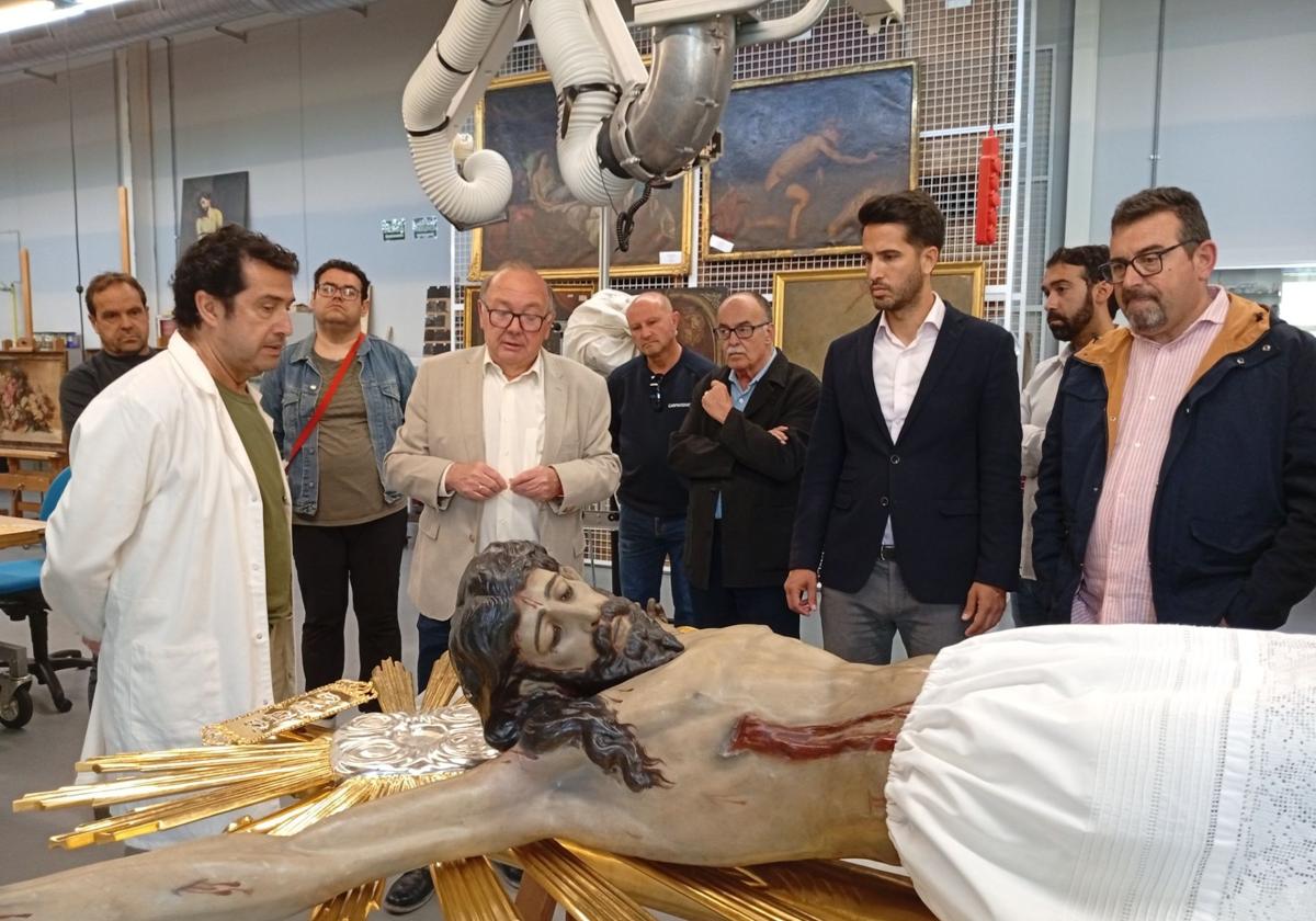 El director del Centro de Restauración, Javier Bernal, el alcalde de Cieza, Tomás Rubio, y representantes de la cofradía, observan la escultura del Cristo del Consuelo.