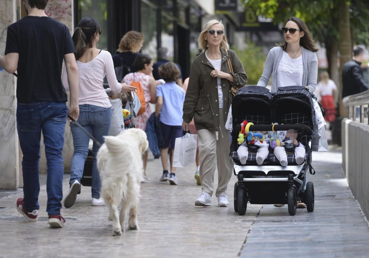 Una madre pasea a sus bebés por una avenida de la ciudad de Murcia.