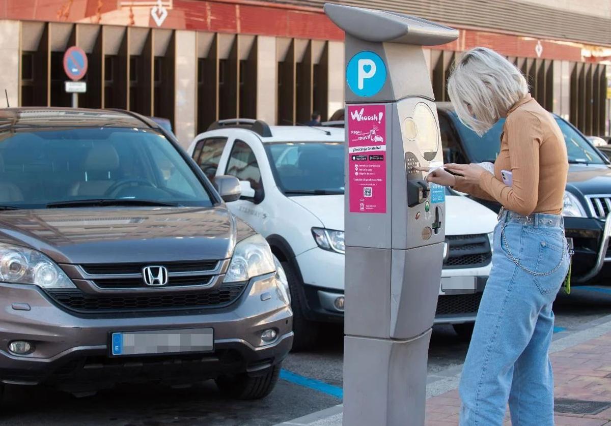 Una usuaria saca un tiquet de un parquímetro en Murcia, en una imagen de archivo.