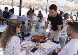 Un camarero sirve la comida a una pareja en un bar de playa de La Manga, en una imagen de archivo.