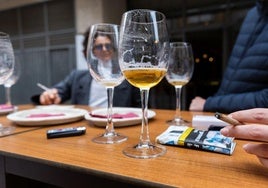 Varios clientes fuman en la terraza de un bar.