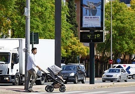 Un viandante pasa en Murcia junto a un termómetro que marca 41 grados al sol, este viernes.