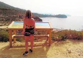 Una senderista contempla las vistas desde uno de los miradores en el camino de las calas de Bolnuevo.