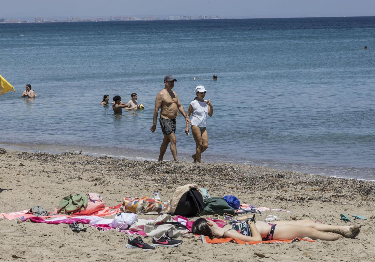 Una mujer tomando el sol en la playa, en una imagen de archivo.