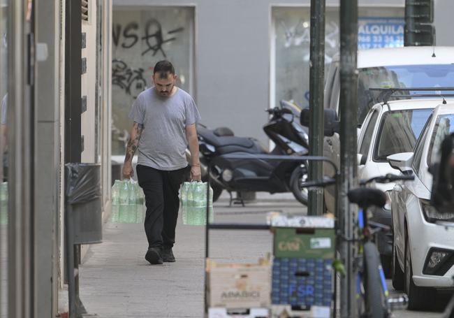 Un hombre carga botellas de agua envasada en Murcia.