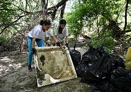 Dos voluntarias retiran un plato de ducha.