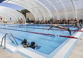 Varios nadadores se lanzan a la piscina olímpica del centro en unas jornadas de la Guardia Civil en el CAR de Los Narejos.