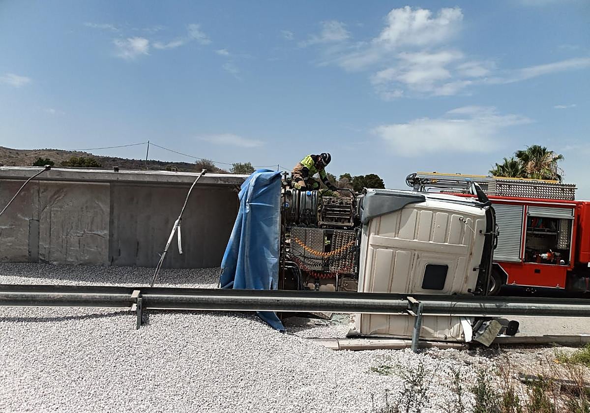 Un bombero trata de rescatar al conductor atrapado.