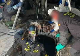 Un agente de la Guardia Civil se introduce en el depósito de aceite donde se encontraron los restos humanos.