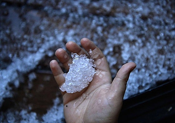 Un hombre recoge granizo caído en su casa en Murcia, en una imagen de archivo.