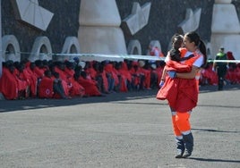 Una voluntaria de Cruz Roja lleva en brazos a un menor llegado en patera en una imagen de archivo.