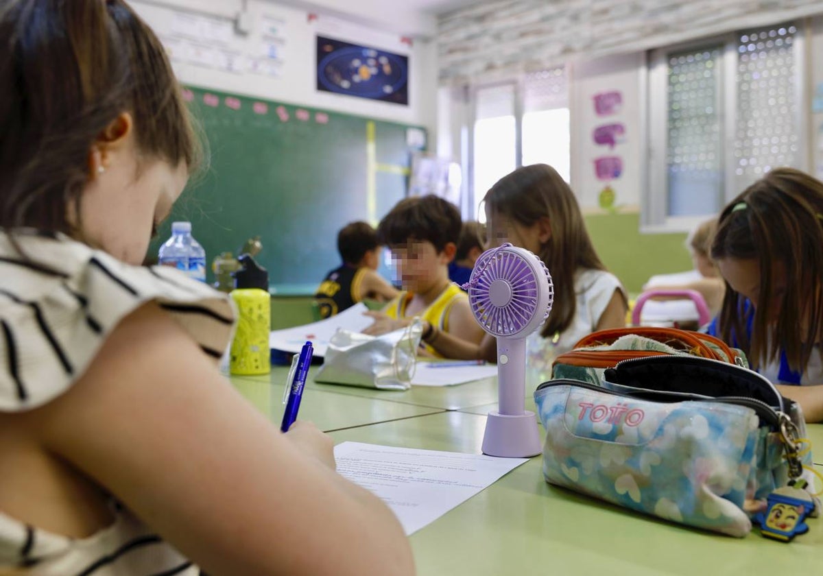 Alumnos en el colegio Luis Costa tratan de mitigar el calor con mini ventiladores y agua.