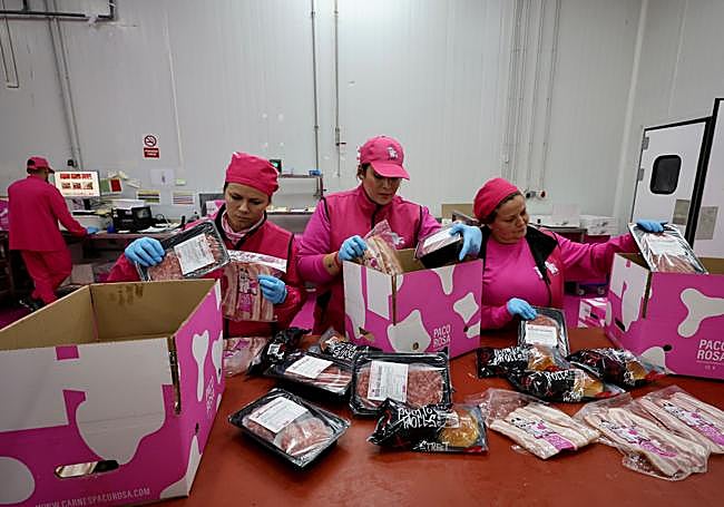 Tres empleadas de la empresa, seleccionando diferentes productos para enviar a domicilio.