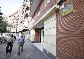 Dos transeúntes pasan junto a la placa con el nombre de la plaza Circular, obra del ceramista Pedro Borja.