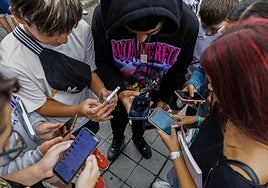 Varios jóvenes miras sus móviles en una imagen de archivo.