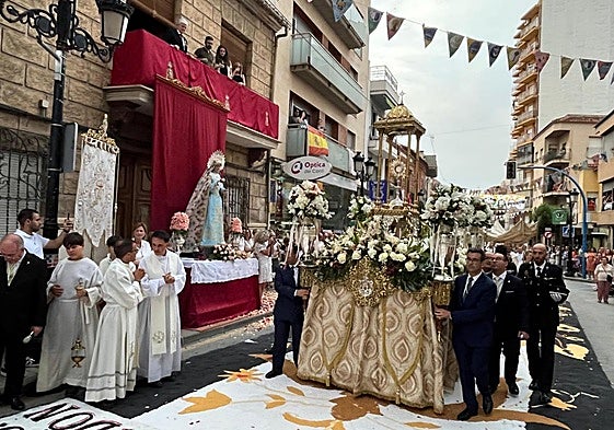 La carroza del Corpus Christi pasa junto a uno de los altares instalados en las calles.