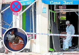Detalle de la bombona presuntamente manipulada e investigadores de la Guardia Civil especializados en incendios inspeccionando el bar de Lo Pagán donde se produjo la explosión.