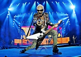 Rudolf Schenker saluda al público en primera fila durante un concierto de Scorpions.