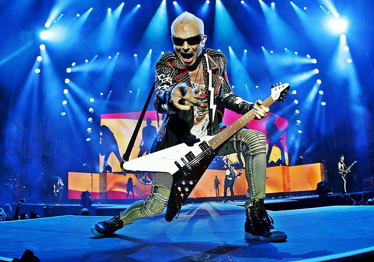 Rudolf Schenker saluda al público en primera fila durante un concierto de Scorpions.