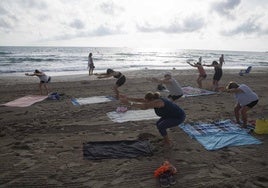 Imagen de archivo de unas mujeres practicando yoga en la playa.