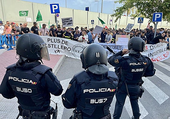 Tres antidisturbios vigilan las protestas de los trabajadores de Navantia frente a la Fremm.