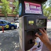 Un usuario sacando un tique en uno de los parquímetros de estacionamiento regulado en la ciudad para las zonas azul y verde.