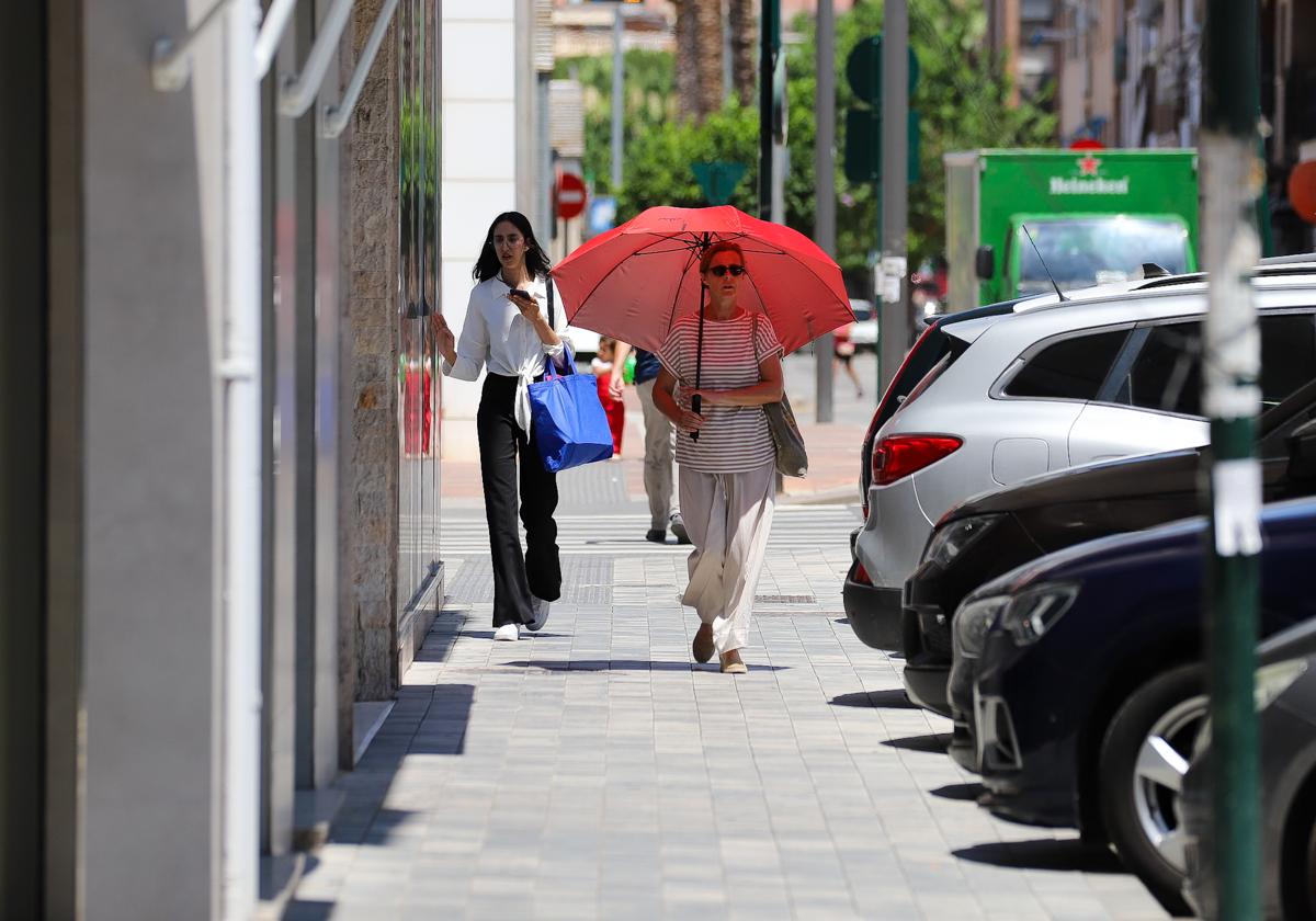 Una mujer con paraguas para protegerse del calor, este jueves en Murcia.
