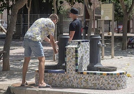 Unos hombres se refrescan en una fuente de Cartagena, en una imagen de archivo.