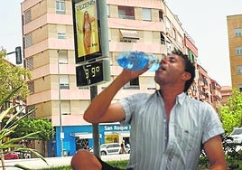 Un hombre bebe agua junto a un termómetro en Murcia, en una imagen de archivo.