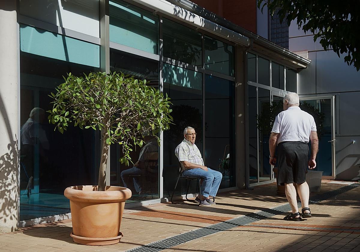Dos hombres pasan el rato al aire libre en una residencia para mayores de El Palmar.