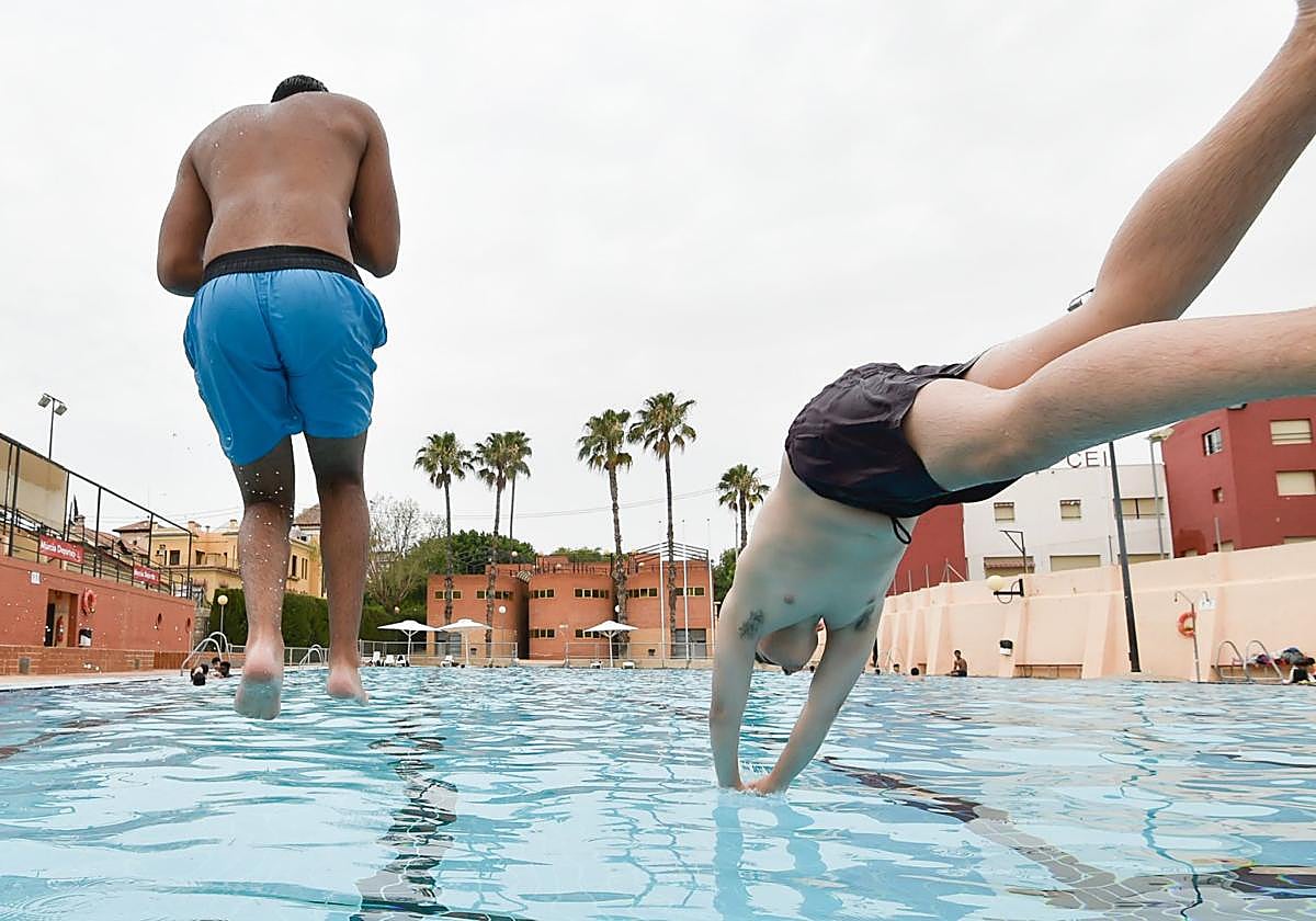 Dos bañistas se lanzan a la piscina municipal Murcia Parque, en una imagen de archivo.