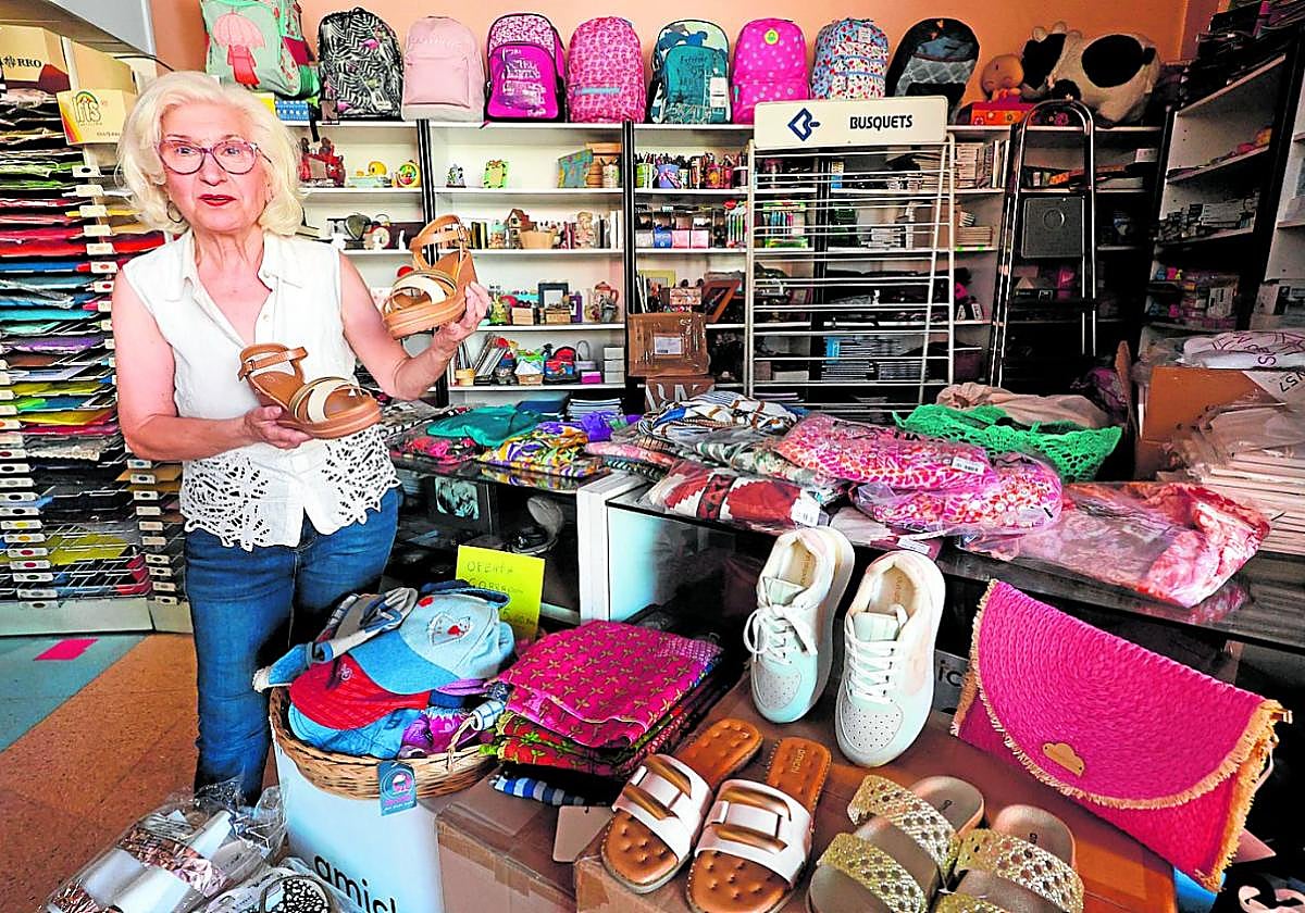 Variedad. María Elvira Fernández muestra unas sandalias que tiene a la venta en su tienda.