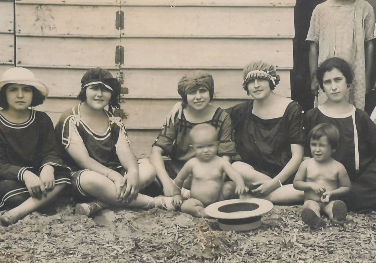 Bañistas en la puerta de una barraca de la playa de La Isla, en una fotografía de la exposición 'Álbum de estío'.