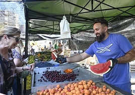 Luis regala una rodaja de sandía a una clienta, ayer en La Fama.