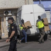 Agentes de la Policía Nacional con pasamontañas descargan cajas en una furgoneta, este martes.