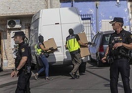 Agentes de la Policía Nacional con pasamontañas descargan cajas en una furgoneta, este martes.
