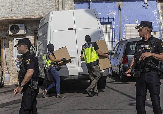 Agentes de la Policía Nacional con pasamontañas descargan cajas en una furgoneta, este martes.