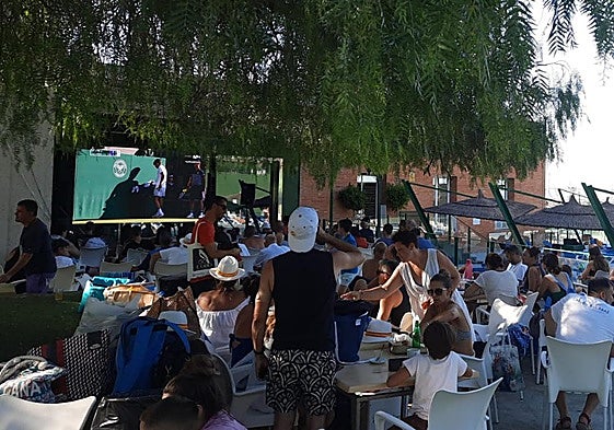 Vecinos de El Palmar se refugian del calor para ver la final de Wimbledon, este domingo.