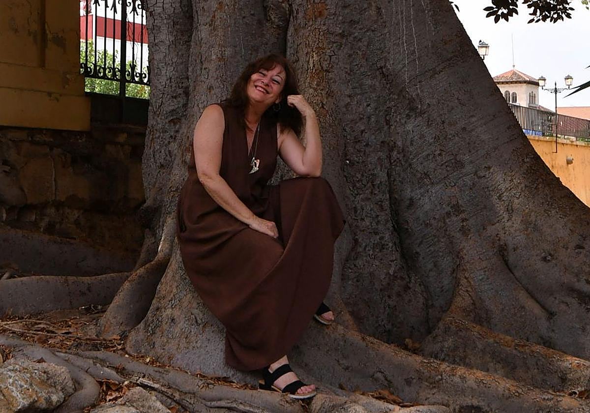 La actriz Inmaculada Rufete, sonriente, acomodada en uno de los árboles más longevos del Malecón, en Murcia.