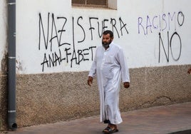 Un vecino con vestimenta árabe pasea por Torre Pacheco entre pintadas de rechazo hacia el racismo.