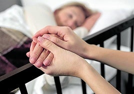 Una sanitaria consuela a una paciente.