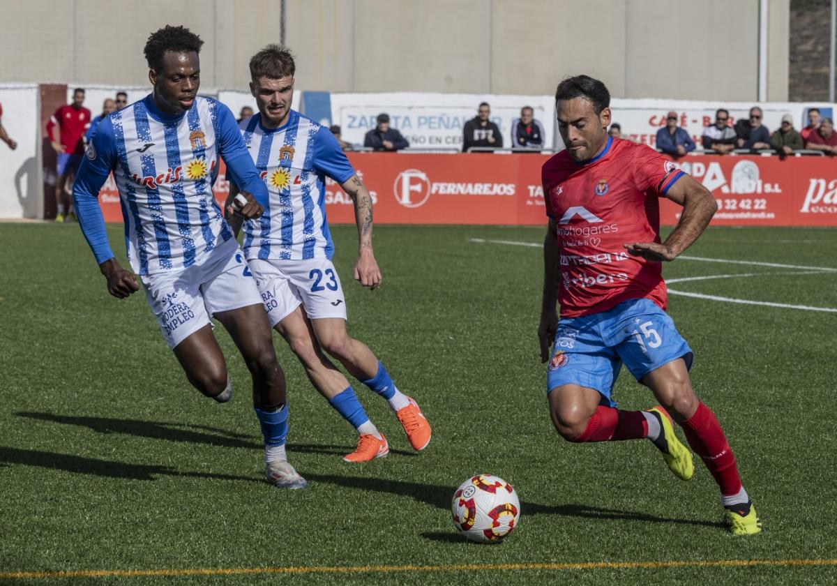 Damián Petcoff, de la Minera, centra un balón ante el marcaje de Ekuba, del Águilas .