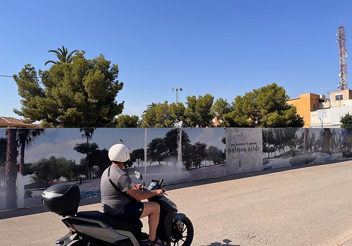 Un motorista pasa junto al recinto ferial, con los vinilos que recrean cómo será el parque.