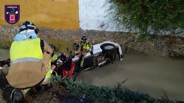 Efectivos rescatan al hombre atrapado dentro de su vehículo tras caer a la acequia.
